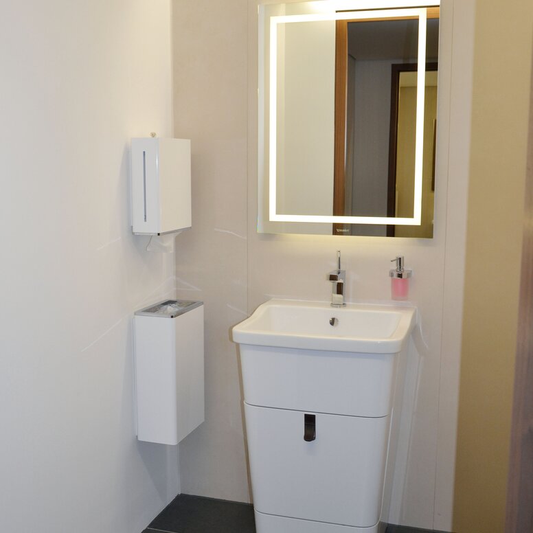 Museum for Architectural Drawings Bathroom equipped with soap dispenser, hygiene waste garbage can, mirror and paper towel dispenser